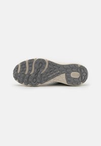 Columbia hiking shoe sole, featuring rubber material, gray upper, beige accents, and textured pattern for grip, with logo prominently displayed.