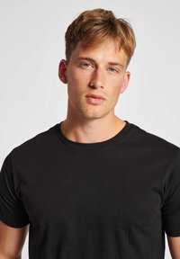 Black short-sleeve cotton t-shirt with a round neckline, fitted design, and smooth texture. No visible patterns or graphics.