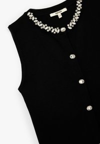 Top sin mangas negro con un escote adornado con joyas que presenta piedras claras y de tono plateado. Cierre frontal con botones y acentos decorativos.
