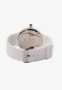 White silicone watch with a silver metal buckle, rounded plastic case, and a flat, metallic back displaying brand and water resistance details.