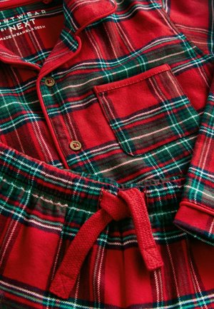 Czerwono-zielony zestaw piżamowy w kratę wykonany z miękkiego materiału; zawiera koszulę zapinaną na guziki z kieszonką oraz spodnie z elastycznym paskiem i sznurkiem.