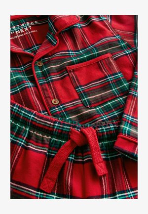 Červená a zelená károvaná sada pyžama vyrobená z měkké látky; obsahuje košili na knoflíky s kapsou a kalhoty na šňůrku v pase.