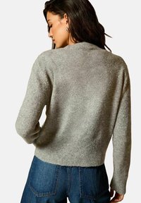 Maglione grigio lavorato a maglia con maniche lunghe, orlo a coste e una texture morbida. Design cropped con scollo rotondo e dettagli minimali.