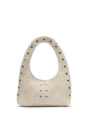 Bež usnjena torbica z zaobljenim ročajem na vrhu, okrašena z enakomerno razporejenimi kovinskimi zakovicami ob robovih in sredini sprednje strani.