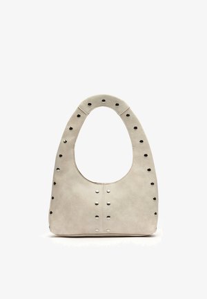 Bež usnjena torbica z zaobljenim ročajem na vrhu, okrašena z enakomerno razporejenimi kovinskimi zakovicami ob robovih in sredini sprednje strani.