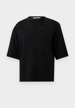 Sort kortærmet sweater med V-udskæring og ribbet kant og ærmekanter på en ensfarvet lys baggrund.