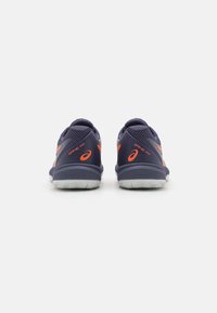 Pantofi sport bleu marin cu textură din plasă, accente portocalii și tălpi din cauciuc. Dispun de un guler și un călcâi căptușite pentru suport.