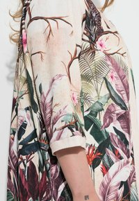 Lichte stof met een roze bloemen- en bladerenpatroon, met tinten groen, paars en accenten in oranje, met opgerolde mouwen en een ontspannen pasvorm.