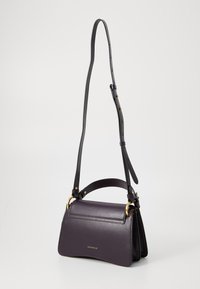 Sac à main en cuir violet avec des accessoires dorés, arborant un design structuré, une bandoulière réglable et une fermeture à rabat à l'avant.