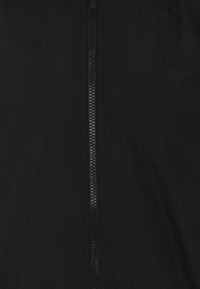 Zwarte jas met een rits over de hele lengte, een gladde textuur en een minimalistisch ontwerp zonder extra patronen of accenten.