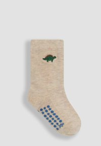 Calcetín de niño pequeño en color beige con bordado de un dinosaurio verde cerca de la parte superior y puntos no deslizantes y estrellas azules en la planta.