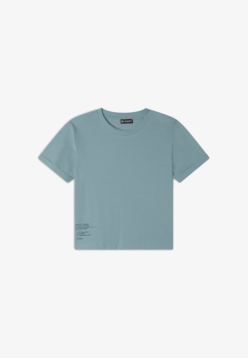 Camiseta de algodón de manga corta y cuello redondo en azul claro, con un detalle de texto impreso en la parte inferior izquierda. Textura suave y fit regular.