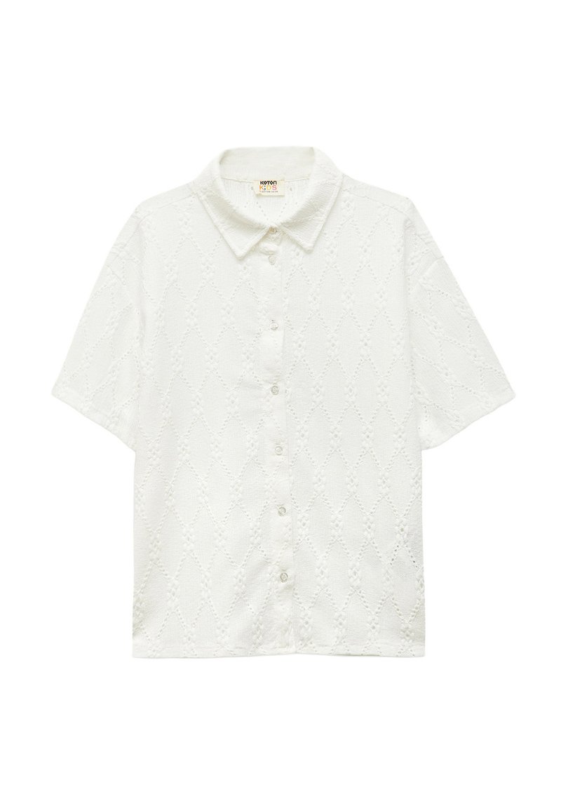 Camisa de manga corta blanca con un patrón texturizado de diamantes, cierre de botones y cuello clásico. Confeccionada en un material de algodón ligero.