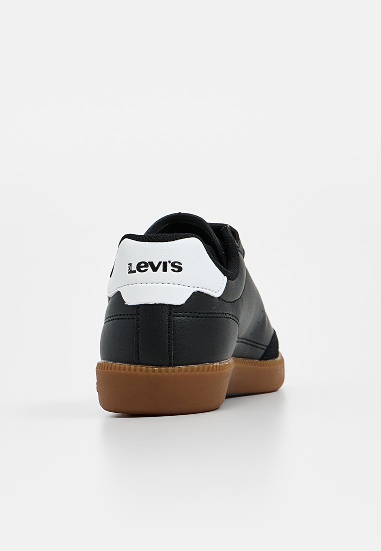 Zwarte sneaker met een glad leren bovenwerk, witte hieltab met het "Levi's" logo en een bruine rubberen zool. Klassiek low-top ontwerp.