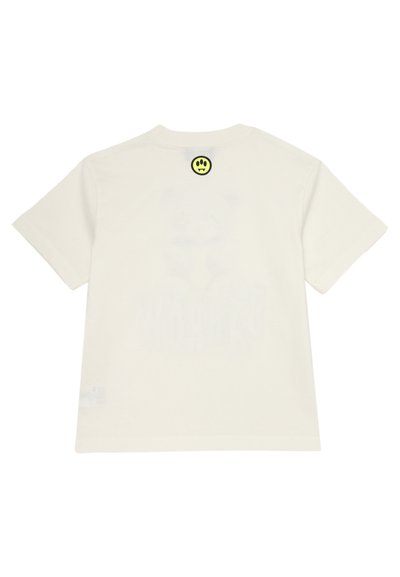 T-shirt bianco in cotone con maniche corte, caratterizzato da un piccolo tag a forma di faccina sorridente di colore giallo neon sul retro e da un motivo sottile sul tessuto.