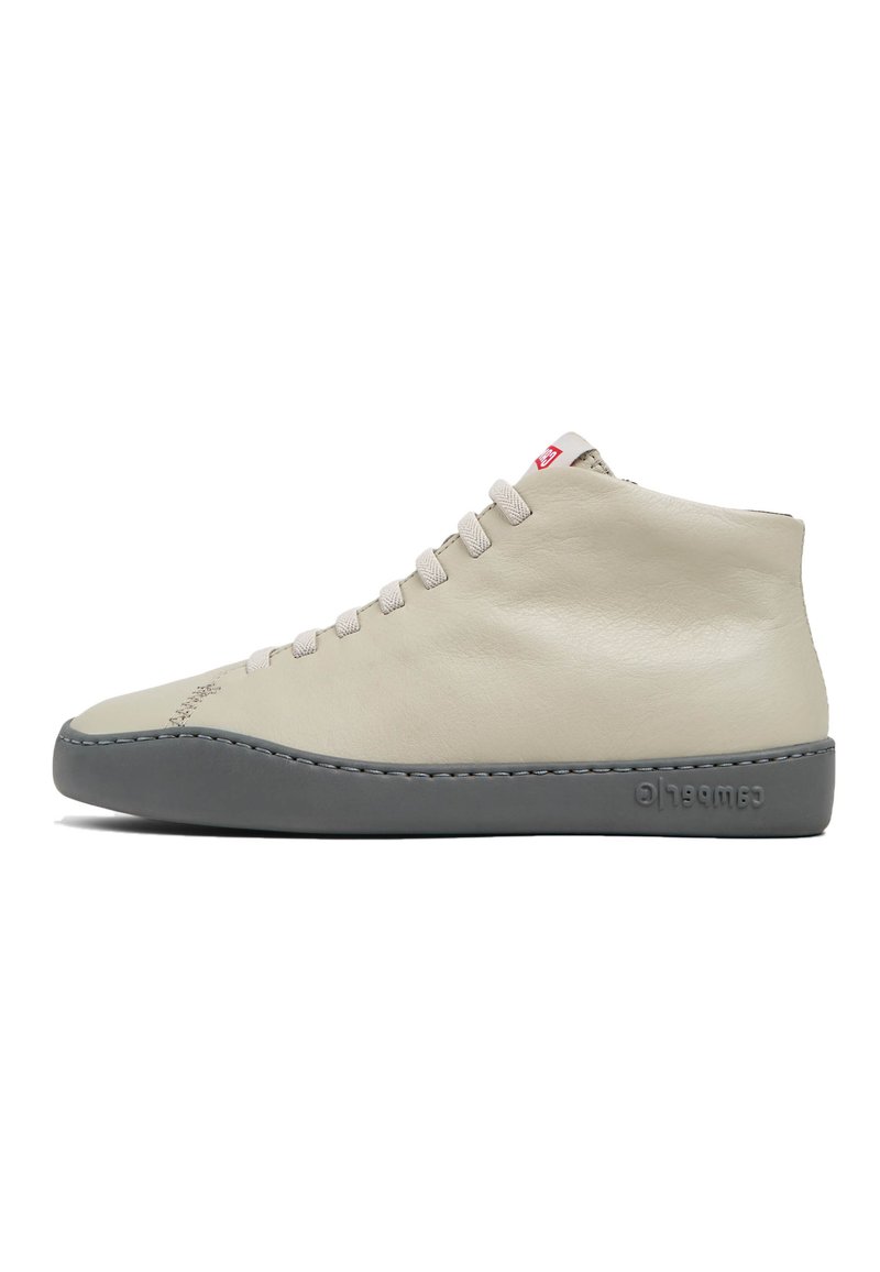 Zapatillas altas de cuero beige claro con suela de goma gris, que presentan cordones estándar y detalles de costura sutiles.