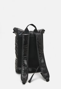 Sac à dos noir avec une finition texturée et brillante. Comprend un dos en mesh rembourré, des bretelles réglables et une fermeture enroulable. Design léger.