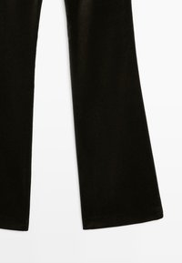 Czarne flared spodnie z weluru o gładkiej fakturze i szerokim kroju nogawek, z eleganckimi wykończeniami i bez widocznych elementów metalowych czy zdobień.