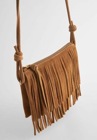 Borsa a tracolla in suede marrone con lunghe frange, chiusura con zip e tracolla annodata per la regolazione. Design semplice e morbida texture.