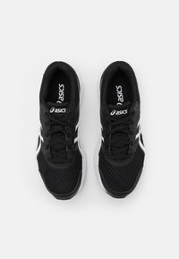 Baskets de sport noires avec une tige en maille, logo et accents blancs, col rembourré et fermeture à lacets plate. La semelle présente des contours pour un meilleur amorti.