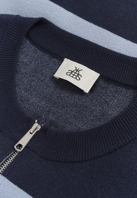 Maglione a strisce blu navy e azzurro chiarissimo, realizzato in maglia, con scollo a costine e chiusura con zip in metallo. Etichetta visibile con branding personalizzato.