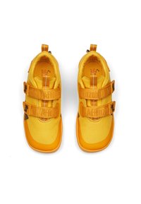Geel sneakers met een textielen bovenkant, rubberen zolen en twee klittenbandsluiting. Rondneuzen ontwerp. De binnenkant heeft een contrasterende gele voering.