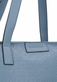 Borsa tote sintetica di colore azzurro chiaro con motivo geometrico testurizzato. Presenta due manici robusti e un'etichetta del marchio sul fronte.