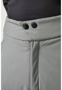 Pantaloni grigi realizzati in un tessuto liscio e testurizzato. Presentano due bottoni neri in vita e un design della cintura pulito.