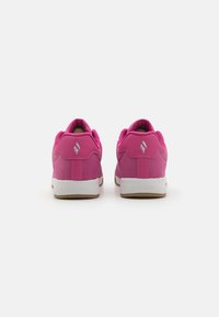 Scarpe sportive in suede rosa con colletto imbottito e suola in gomma bianca. Presentano un piccolo logo argento sul retro.