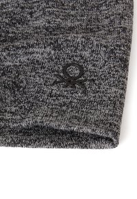 Cappello a maglia nei toni del grigio con motivo a trama e dettaglio logo nero sul davanti. Risvolto piegato nella parte inferiore.