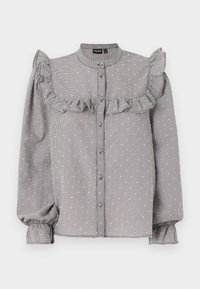 Svart och vit rutigt blus med volangdetaljer över bröstet, långa puffärmar med elastiska manschetter och knäppning framtill.