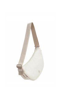 Sac bandoulière en tissu crème avec une forme arrondie et une sangle beige réglable ; présente un logo discret et un biais coloré en bas.