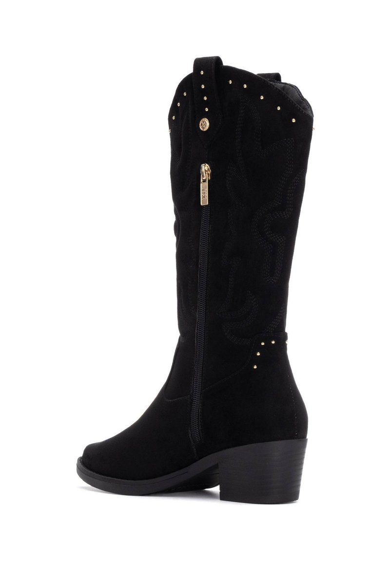 Botas de tobillo de ante negro con un diseño texturizado, acentos de tachuelas doradas, cremallera lateral y tacón cuadrado. Costura decorativa en la parte superior.