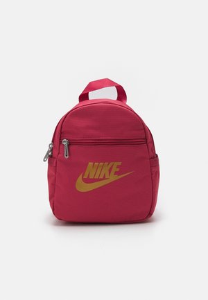 Petit sac à dos rouge Nike avec poche avant zippée, poches latérales, poignée supérieure et logo Nike doré sur le devant.