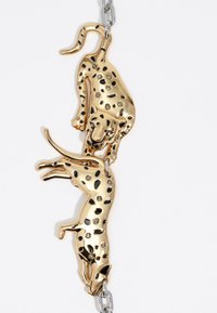 Spilla in tonalità oro a forma di leopardini con due leopardi dai punti neri e decorazioni trasparenti, collegati da una catena argentata.