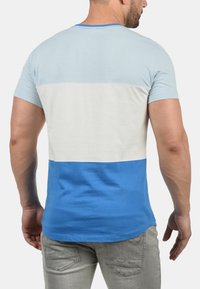 Kortermet t-skjorte med horisontale striper i lyseblått, hvitt og mørkere blått. Laget av myk bomullsblanding.