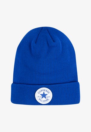 Kék kötött sapka felhajtott szélekkel, középen egy kerek fehér címkével, rajta a "Converse Chuck Taylor" felirattal és egy csillaggal.