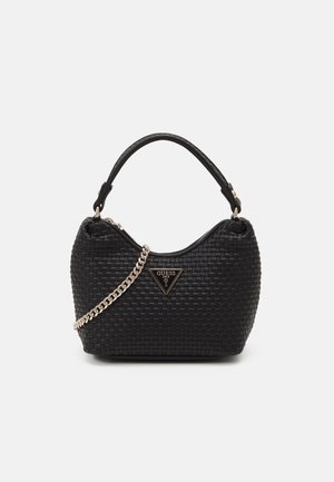 Schwarze, gewebte Handtasche mit kurzem Henkel, goldener Kettenriemen und dreieckigem Guess-Logo in der vorderen Mitte.