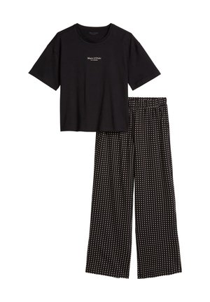 Zwart Marc O’Polo T-shirt met korte mouwen gecombineerd met zwarte wijde broek met een klein wit polkadotpatroon.