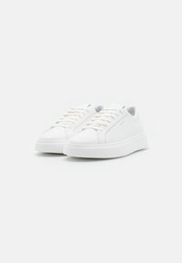 Witte leren sneakers met een ronde neus, platte veters en een gestructureerde zool. Ze hebben een minimalistisch ontwerp zonder zichtbare branding.