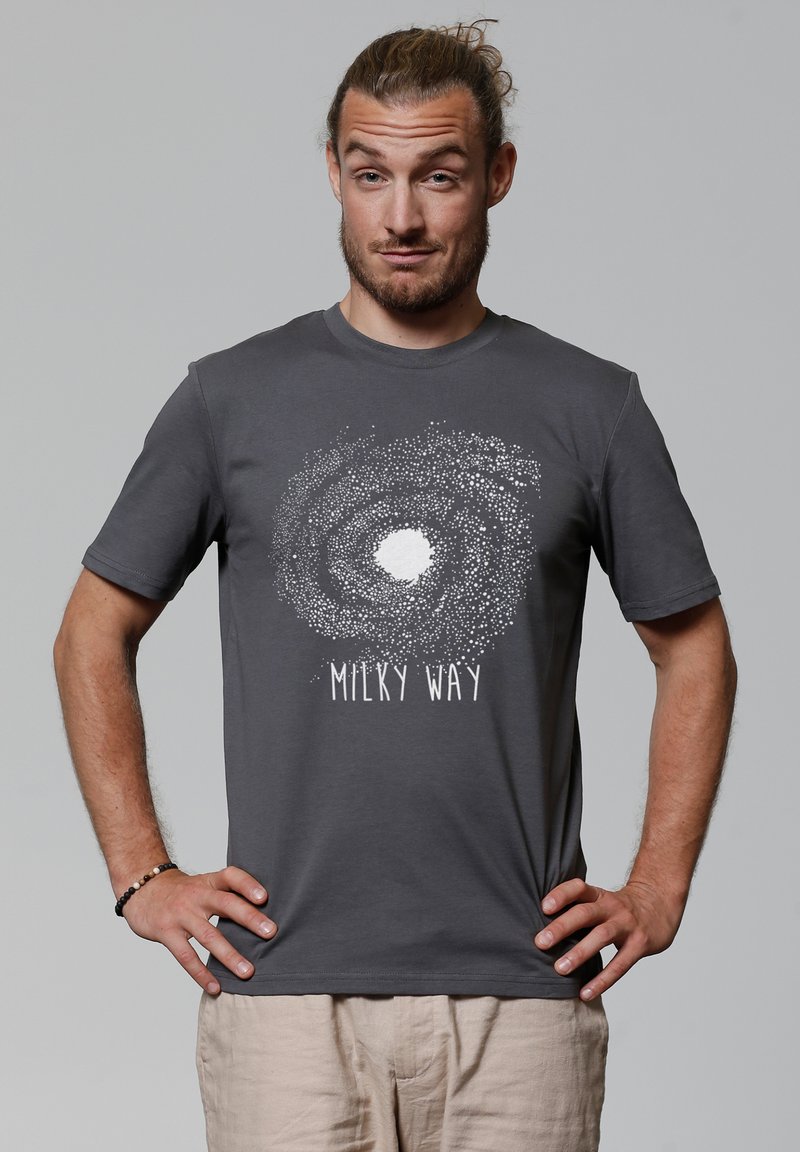 Grijze katoenen t-shirt met een witte grafische afbeelding van een melkweg en de tekst "MILKY WAY" eronder. Korte mouwen en ronde hals.