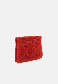 Czerwony prostokątny szydełkowany kopertówka z klapką, pokazana stojąca na białym tle.