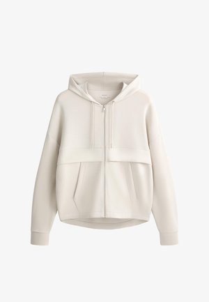 Jasnobeżowa bluza z kapturem na zamek, z suwakiem z przodu, kapturem ze sznurkiem, długimi rękawami oraz dwoma przednimi kieszeniami widocznymi na białym tle.