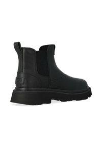 Stivale Chelsea in pelle nera con pannelli laterali elastici, punta tonda, suola spessa in gomma e piccolo logo impresso sul tallone.