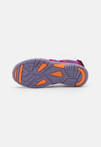 Sola de um sapato atlético roxo com um design texturizado e detalhes laranja, construída em borracha resistente para melhor aderência e durabilidade.