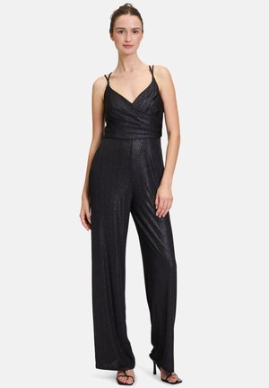 Combinaison noire avec un corsage ajusté, décolleté en V et fines bretelles spaghetti. Fabriquée dans un tissu brillant avec des jambes larges et fluides.