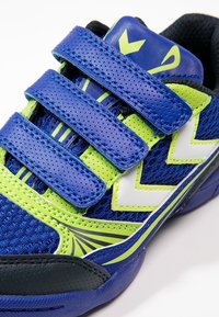 Kinder at shoes in blauw en groen, met drie klittenbandstraps, een bovenwerk van mesh, rubberen zool en een zigzag accentpatroon.