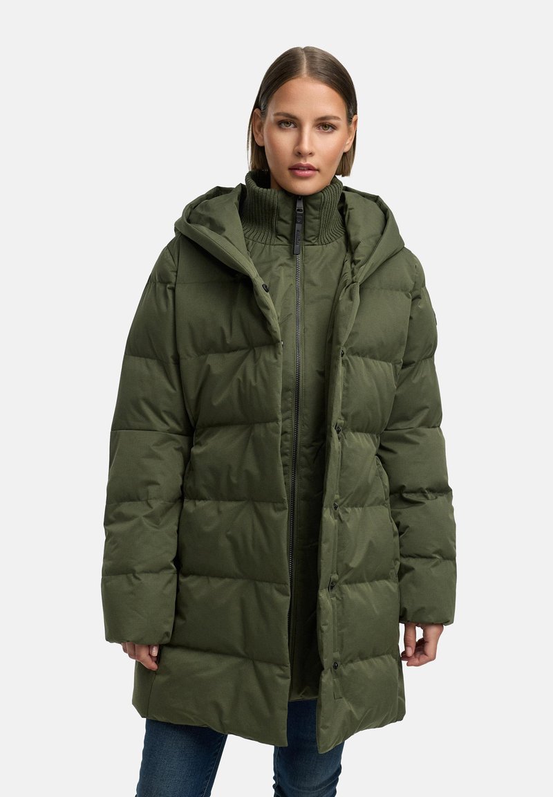 Olīvzaļš pildīts mētelis ar kapuci, ar augstu apkakli, rāvējslēdzēju un pogu apdari; strukturēta auduma ar kviltēta rakstu.