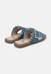 Blauwe denim instapsandalen met rafelige randen en strasstenen accenten. Platte zolen met een zachte binnenvoering voor comfort.