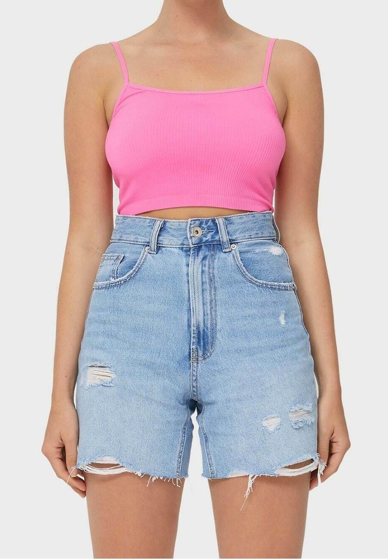 Rosa ribbat crop top med tunna axelband, parat med högmidjade, slitna, ljusblå jeansshorts med fransar och fickor.